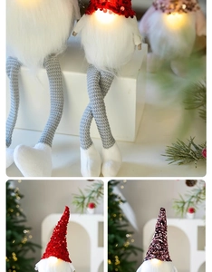 Close-up of glowing LED Christmas gnomes with red sequin hats and long white fur beards