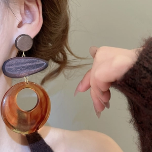 Close-up of model wearing retro wood and amber resin drop earrings with gold links