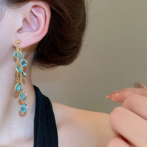 Dettaglio degli orecchini a nappa lunga placcati in oro 18k con perle di vetro blu