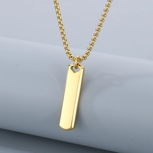 Macro detail of high-polished gold stainless steel rectangular bar pendant and chain