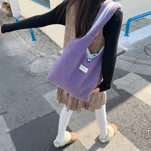 Close-up of purple plush tote bag showing soft faux fur texture and white studio label