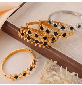Detailed view of honeycomb titanium steel bracelets with black enamel in a wooden jewelry box