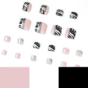 Pink and zebra stripe press-on toenails with silver glitter accents on white background