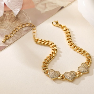 Close-up of 18K gold plated Cuban chain bracelet with three sparkling zircon hearts