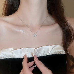 Close-up of a silver star-shaped pendant necklace with sparkling crystals on a model