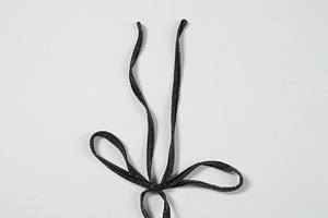Detailed close-up of metallic glitter texture on a black v-neck dress string tie