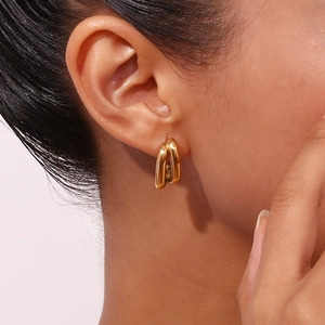 Close-up of a model wearing minimalist double-layered 18K gold-plated stainless steel earrings