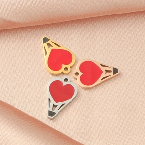 Detailed view of gold, rose gold and silver heart-shaped hot air balloon charms on satin