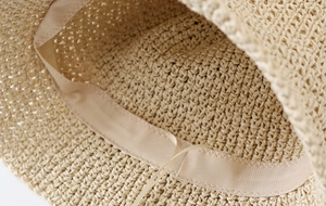 Detailed view of the woven straw hat interior featuring a sweatband and adjustable drawstring