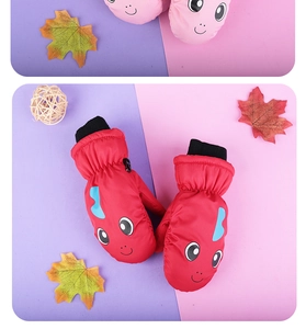 Detail of pink and red waterproof winter mittens with cartoon dinosaurs and adjustable straps