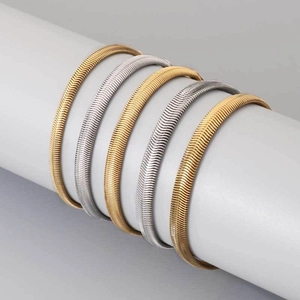Set di 5 bracciali a spina di pesce oro e argento su un supporto da esposizione