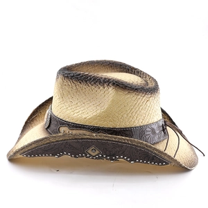 Detail of western straw cowboy hat with leather band, studs and vintage spray finish