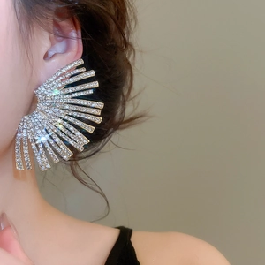 Macro detail of silver fan-shaped statement earrings with sparkling rhinestones