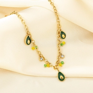 Detail of gold chain necklace with green enamel avocado pendants and small crystal beads