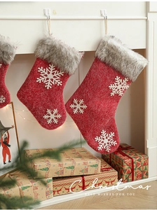 Detail of red felt Christmas stocking with white snowflake and grey faux fur trim