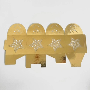 Flat lay of laser-cut gold star candy box template with heart details on metallic paper