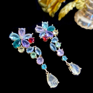Detailed macro view of colorful crystal flower earrings with gold finish and teardrop gems
