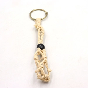 Detail of hand-woven beige cotton mesh pendant holder with black bead and gold ring