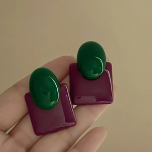 Detailed close-up of retro geometric earrings featuring purple square and green oval resin