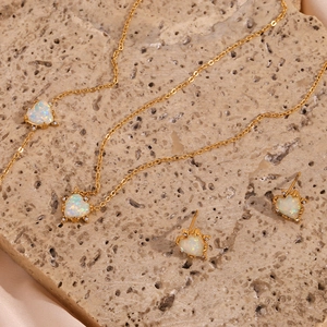 Detailed macro view of heart-shaped opal necklace and earrings set in gold finish