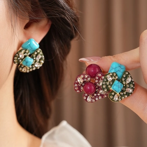 Detailed view of vintage turquoise and burgundy stone earrings with gold metal accents