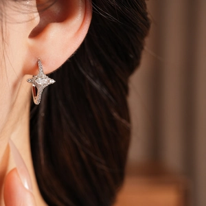 Detail of star hoop earring with pavé zircon and marquise center stone on model ear