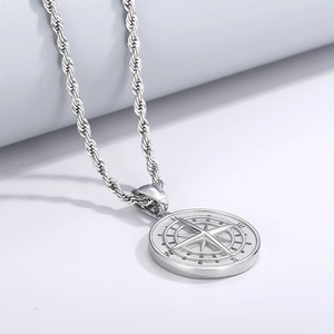 Vue détaillée du pendentif boussole en acier inoxydable argenté sur une chaîne torsadée