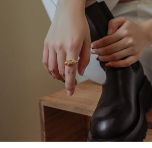 Detailed view of an 18K gold plated titanium ring featuring a unique double ball design