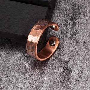 Macro detail of copper magnetic therapy ring with hammered texture and interior magnets