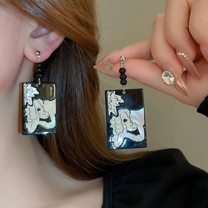 Detail of vintage gothic rectangle earrings with a white dog motif on black base