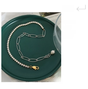 Detail of a mixed-chain necklace with sparkling zircons and a teardrop pearl pendant