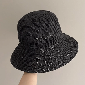 Detail of hand-crocheted black straw sun hat showing high-density woven texture