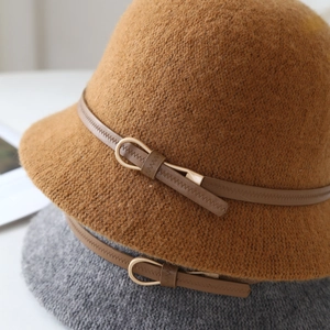 Detail of wool bucket hat with leather strap and golden buckle in caramel and grey