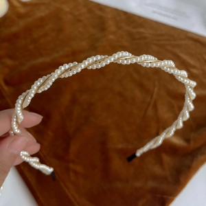 Close-up of elegant double-layered pearl headband with golden metallic twist detail