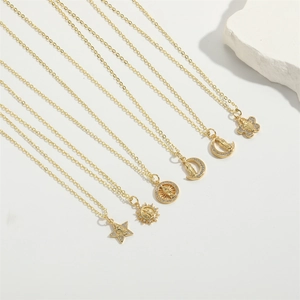 Close-up of 6 gold star and moon pendant necklaces with religious embossing and crystals