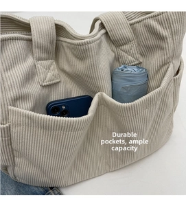 Détail du cabas en velours côtelé avec poches avant pour téléphone et parapluie plié