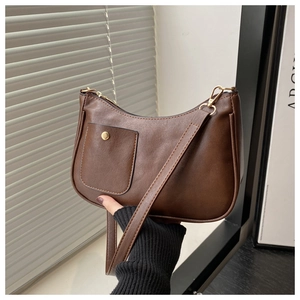 Detail of vintage brown shoulder bag showing front pocket with gold snap button