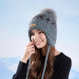 Winter gray knit trapper hat with pompom and earflaps for outdoor cold protection