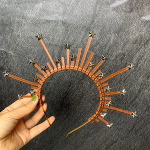 Macro detail of sunburst halo headband with metallic stars on a copper base