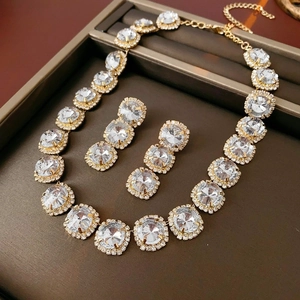 Detail view of crystal water drop necklace and earrings set on a textured display tray
