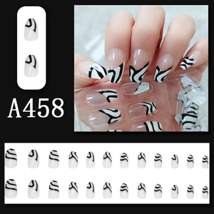 Macro detail of coffin shaped press-on nails with black and white zebra fluid patterns