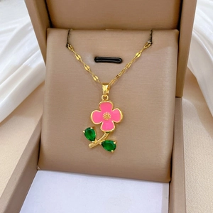 Vue détaillée du pendentif fleur en émail avec pétales roses et zircons verts