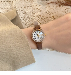 Close-up of quartz watch with shell dial, roman numerals and brown leather strap