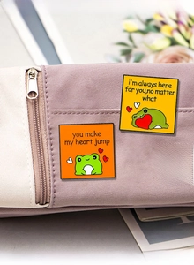 Detail of cute enamel frog badges on a canvas bag featuring romantic English text quotes