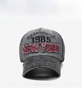 Detail of vintage washed grey baseball cap with 1985 New York embroidery and distressed brim