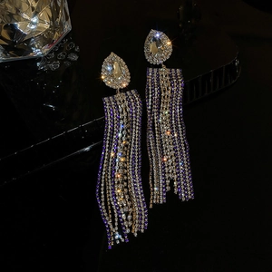 Macro shot of long tassel earrings with blue and white teardrop rhinestones
