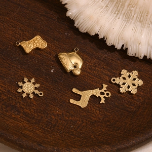 Dettaglio di ciondoli natalizi placcati in oro 14K con renne e fiocchi di neve
