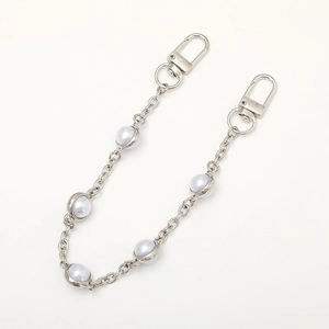 Short metal phone charm chain with white pearls and silver lobster clasps on white background