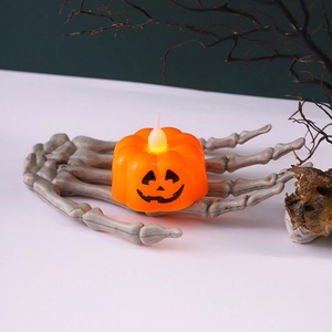 Candela LED a forma di zucca di Halloween tenuta da una mano di scheletro