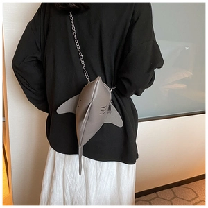 Detailed view of a creative grey leather shark-shaped crossbody bag with a silver chain strap